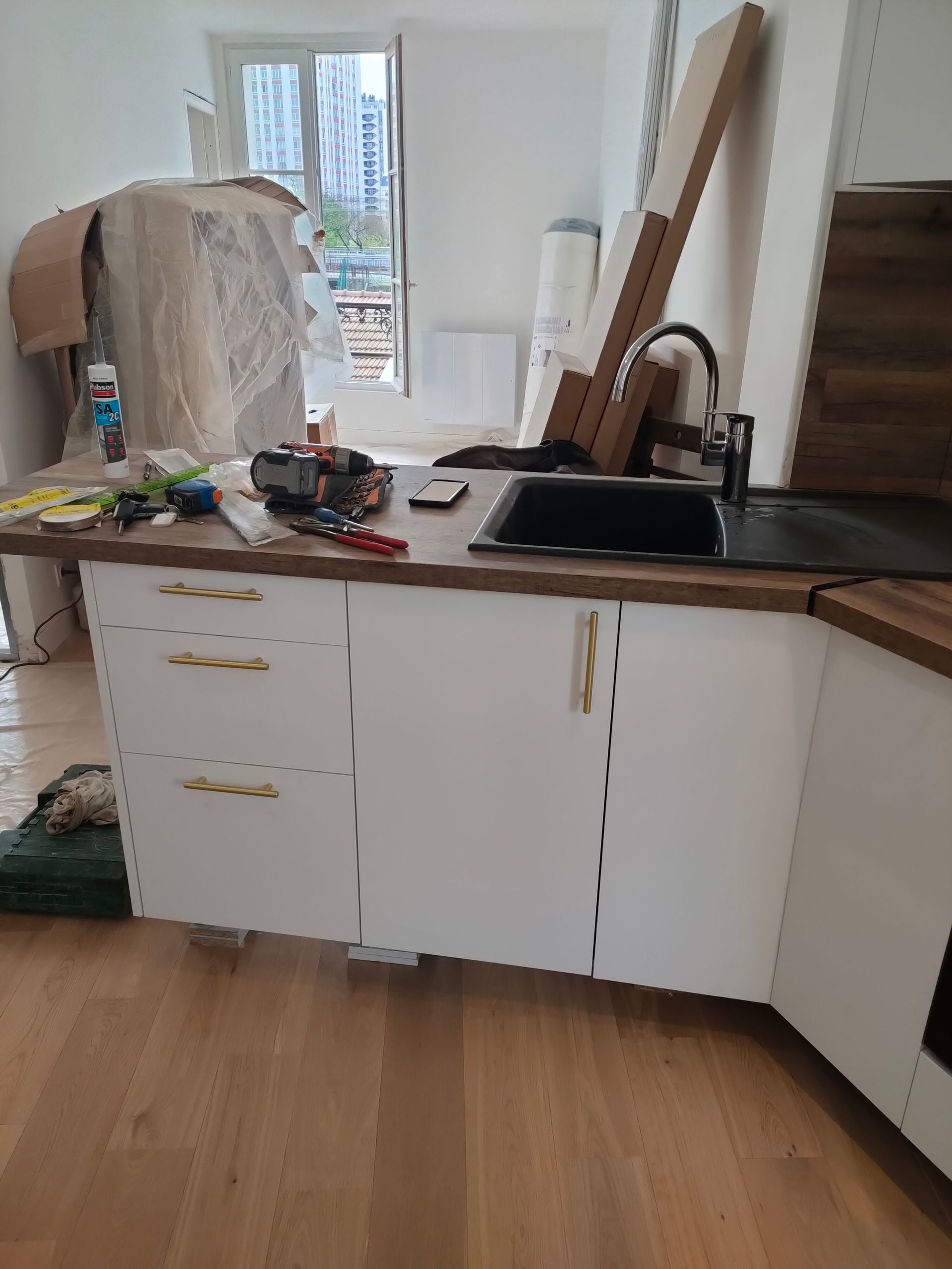 Un comptoir de cuisine dans une pièce avec du parquet - Entreprise Haikal