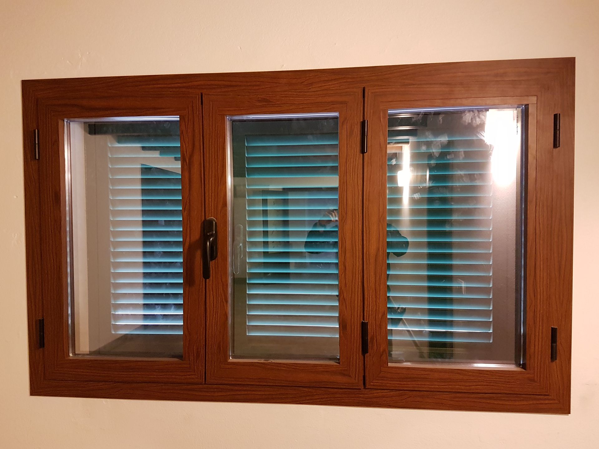 Una ventana de madera con persianas azules.