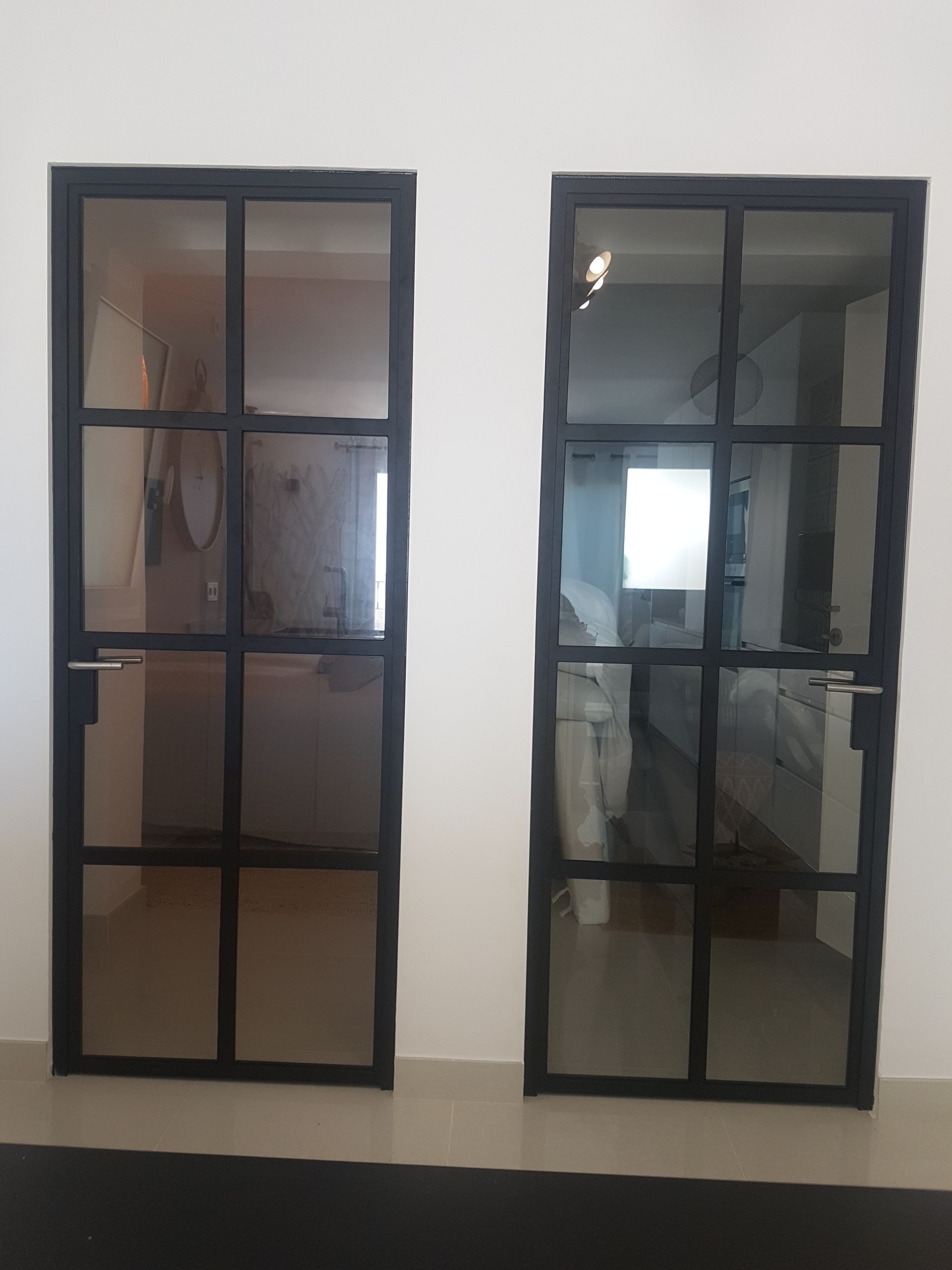 Hay dos puertas de cristal una al lado de la otra en una habitación.