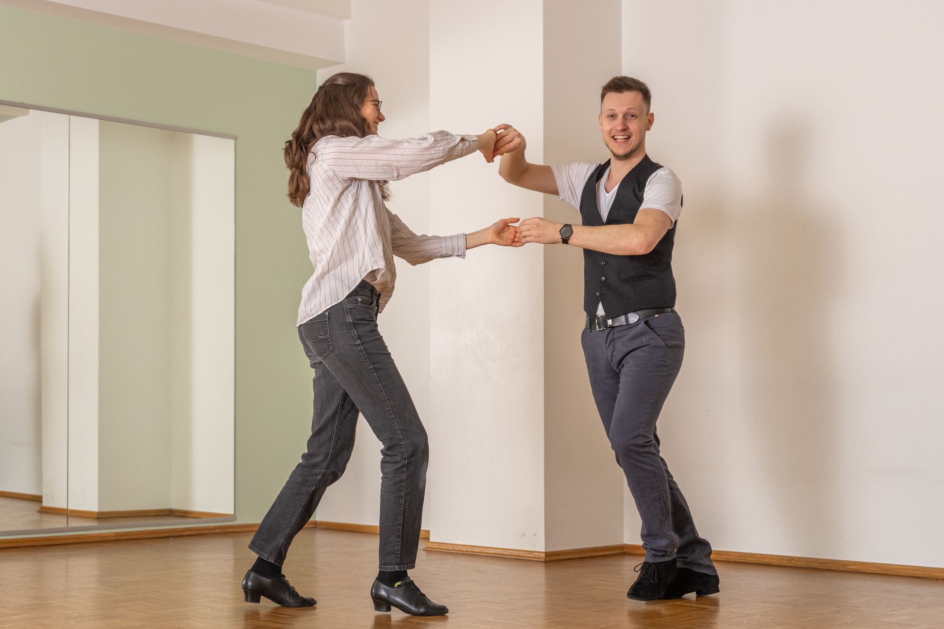 Zwei Personen führen eine Drehung beim Discofox-Tanzen in einem hellen Raum aus