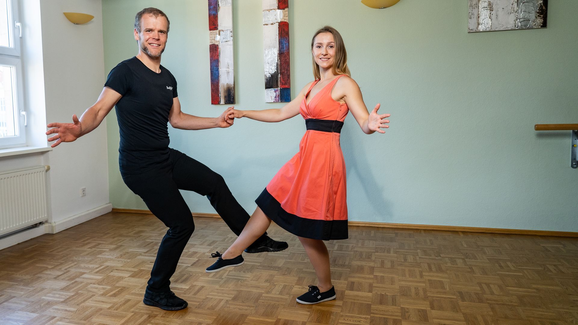 Zwei Personen tanzen schwungvoll Lindy Hop oder Rock’n’Roll in einem Tanzraum
