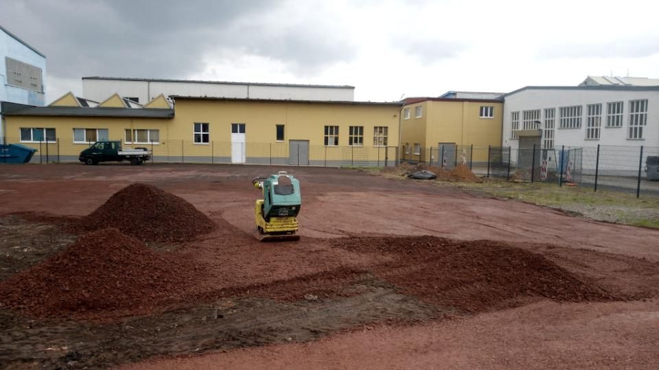 Ronny Mätzold Maurer- eine rote Schotterfläche vor einem gelben Gebäude