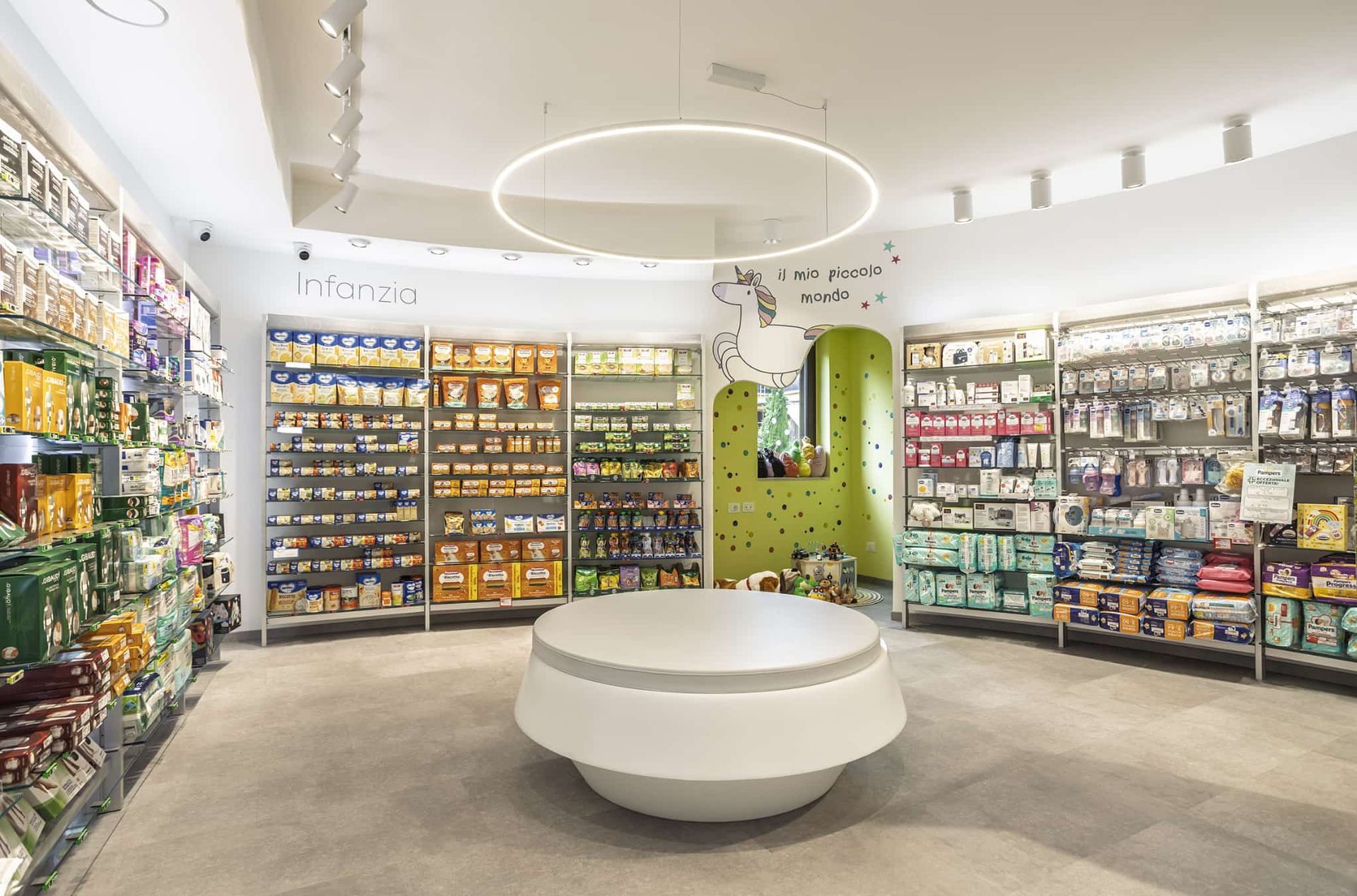 Una farmacia con il simbolo della croce verde sulla porta d'ingresso, su una strada fiancheggiata da alberi ed edifici.