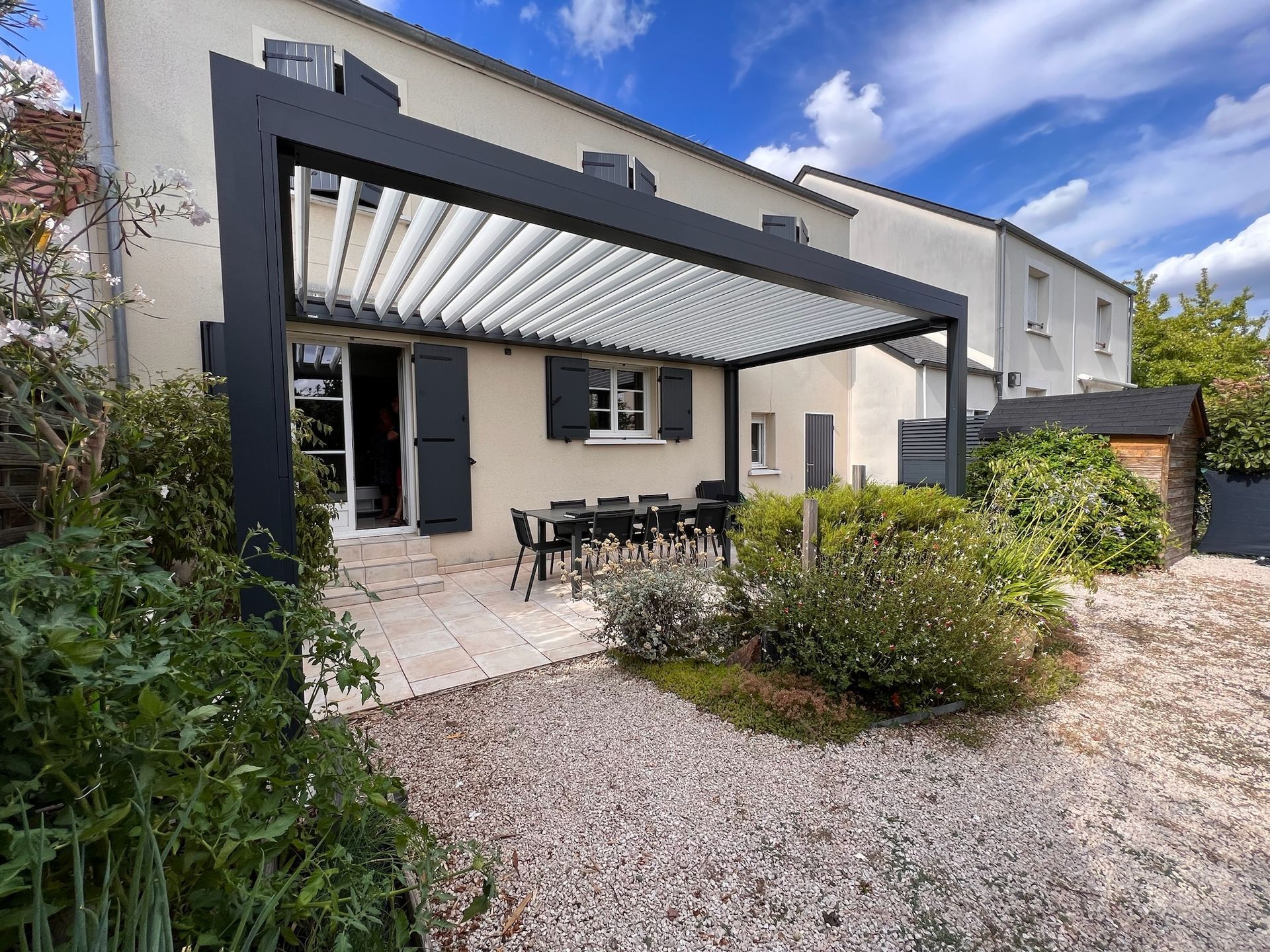 Terrasse arrière avec pergola gris foncé, table et chaises
