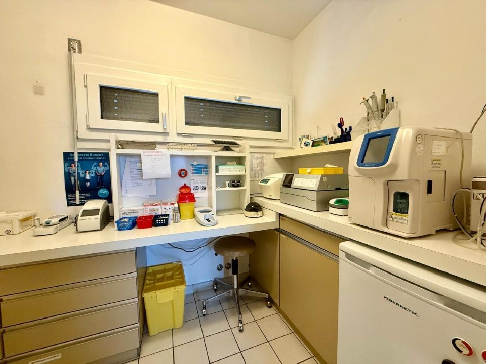 Spazio di lavoro in laboratorio con attrezzature, armadietti e una finestra.