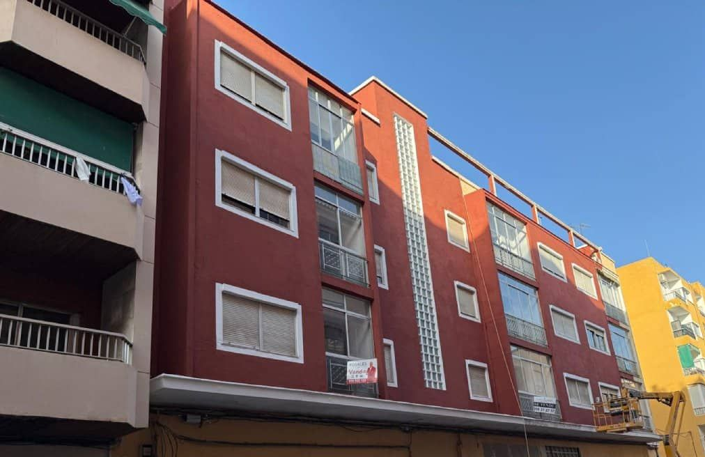 Edificio de apartamentos rojo con múltiples ventanas.