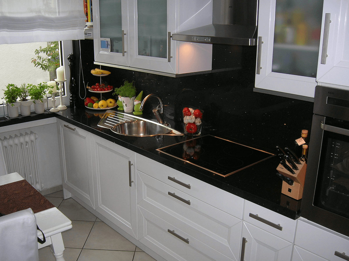 Küche mit quarzkomposite Arbeitsplatte und Nischenrückwand