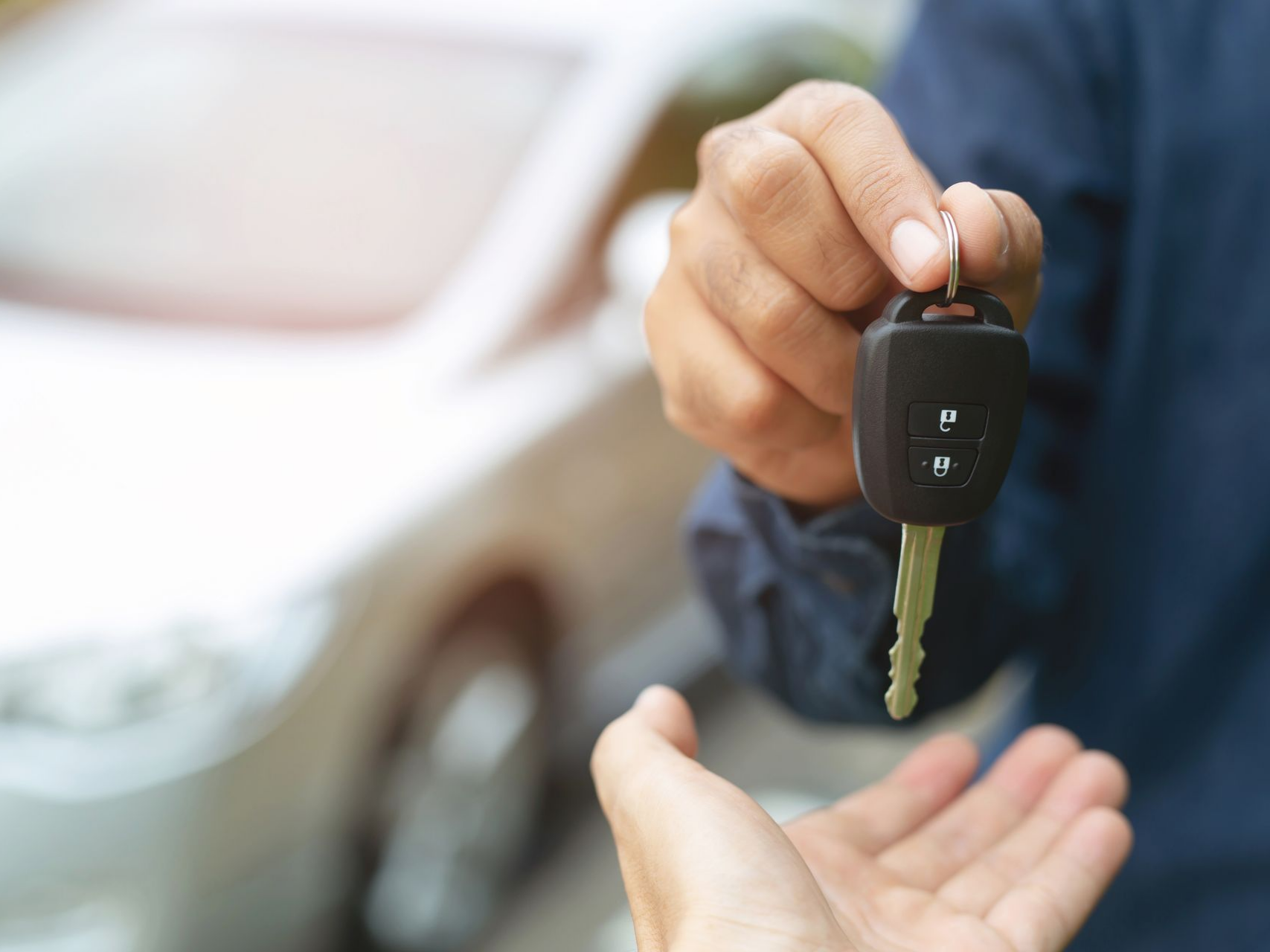 Une personne remet une clé de voiture à une autre.