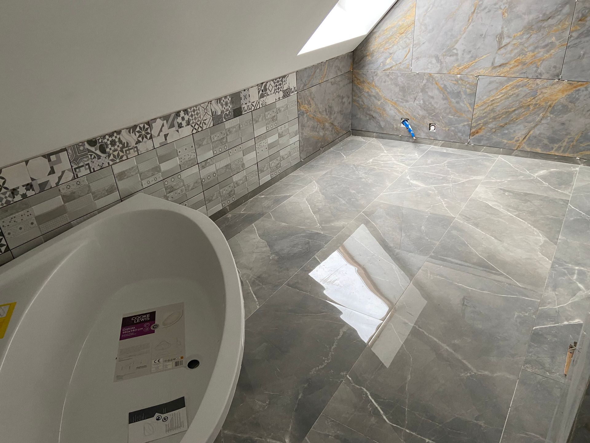 Une baignoire d'angle et du carrelage mural