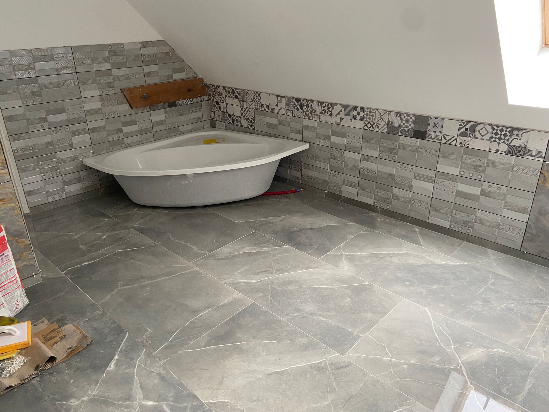 Une baignoire d'angle et du carrelage