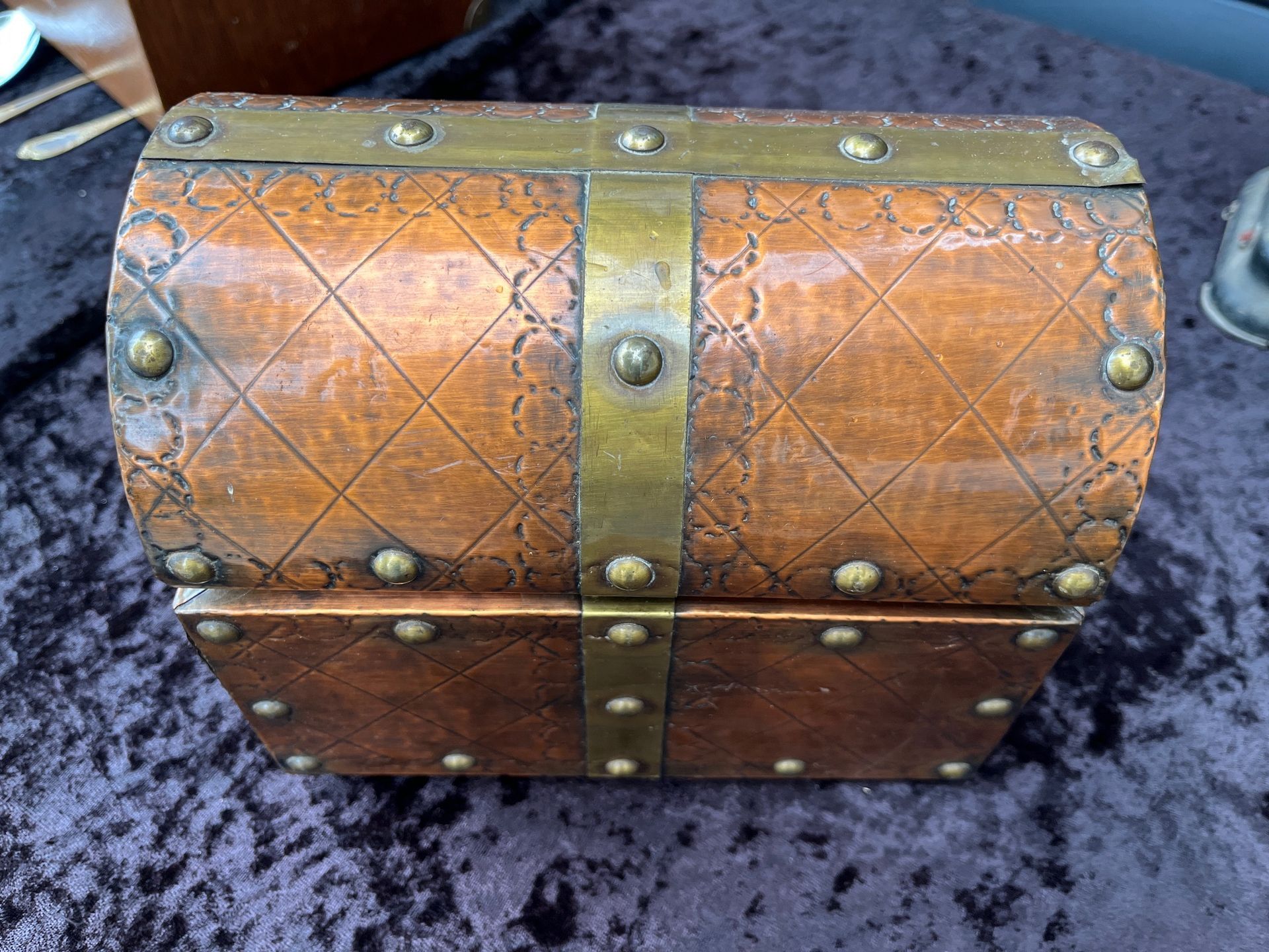 Petit coffre en bois brun avec des bandes et des rivets métalliques