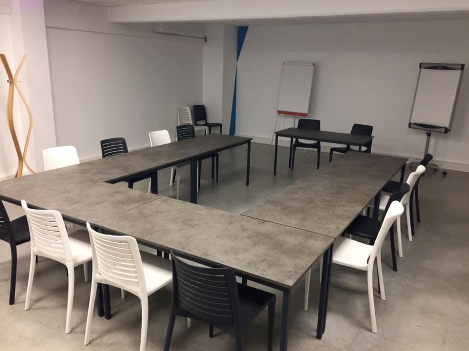 Salle de réuinon avec tables disposées en U
