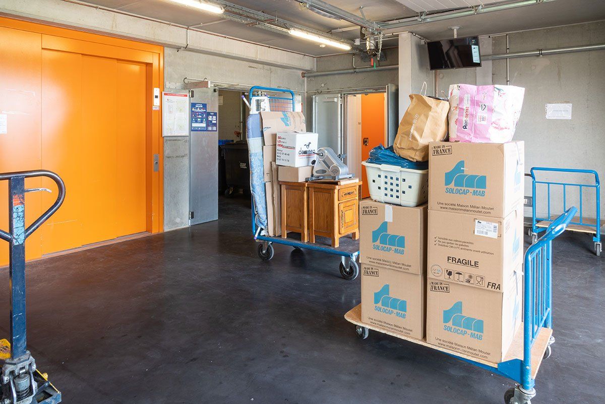 Chariots avec des cartons devant l'ascenseur d'Auvergne Self Stockage