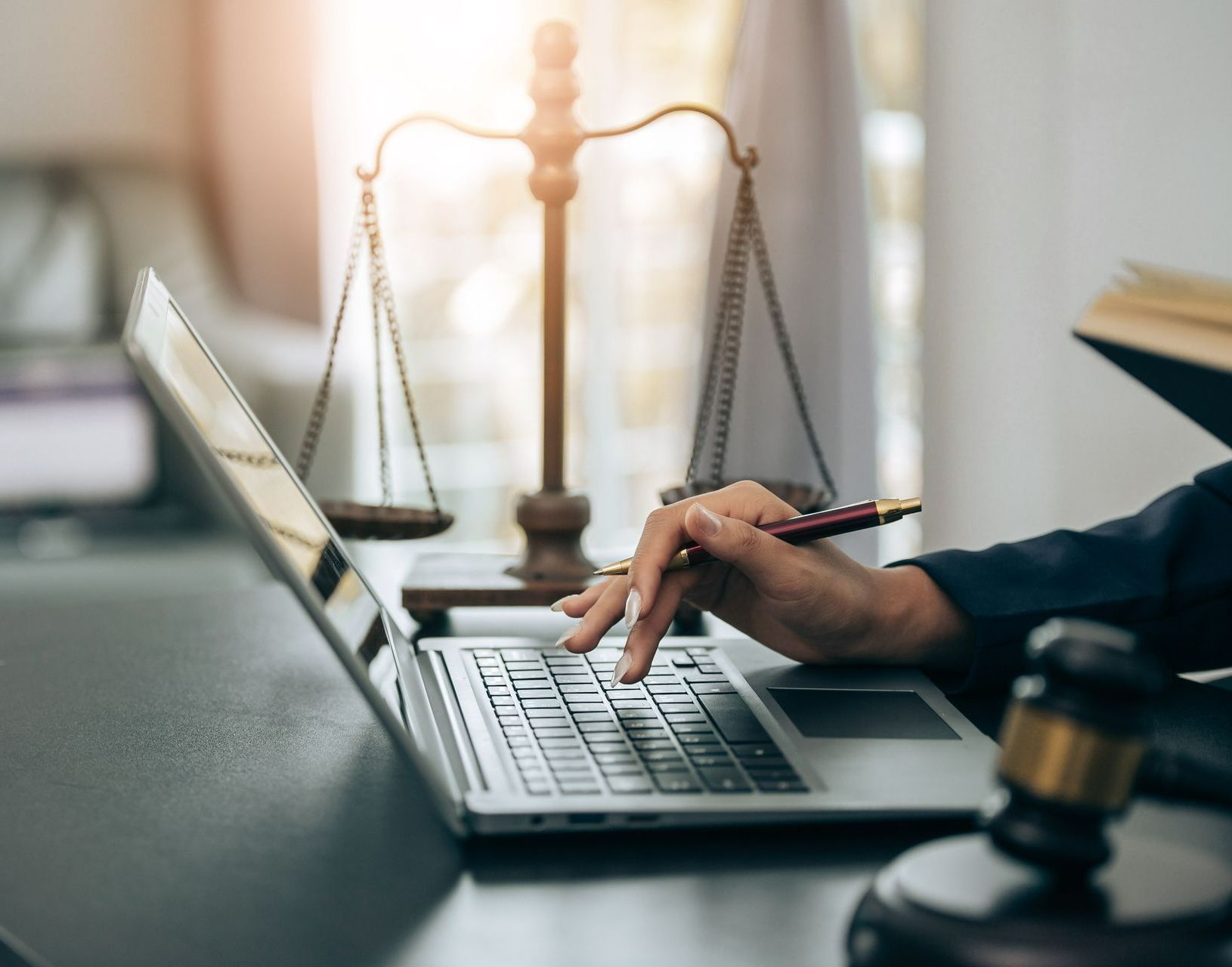 Main de l'avocate tapant sur un clavier d'ordinateur