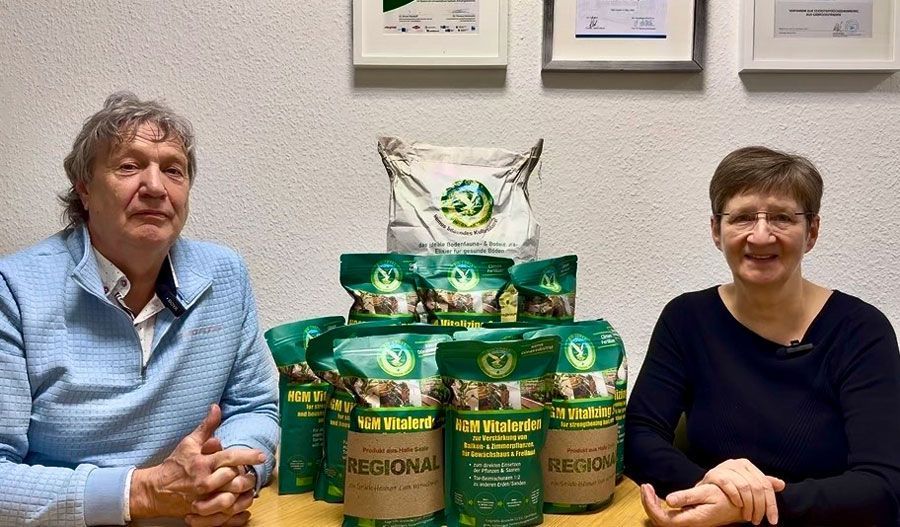 Eine Gruppe von Menschen steht in einem Raum um einen Tisch herum.