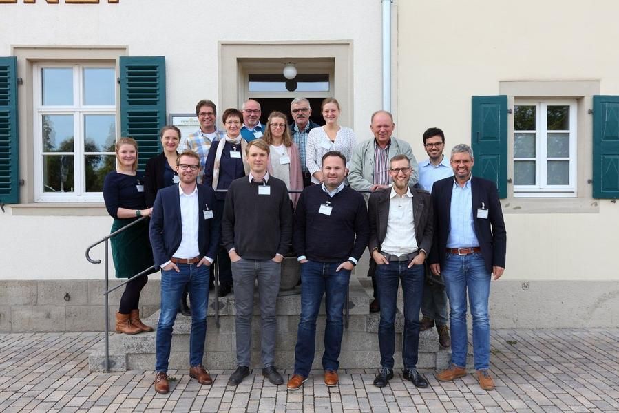 Eine Gruppe von Menschen posiert vor einem Gebäude für ein Foto.