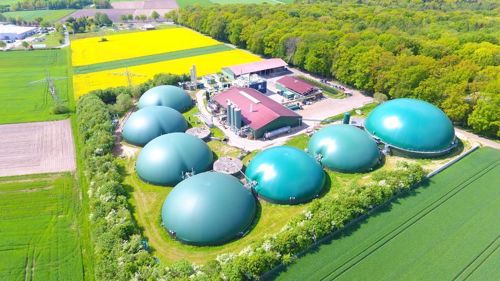 Eine Luftaufnahme einer Farm mit vielen grünen Kuppeln inmitten eines Feldes.