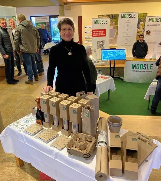 Eine Frau steht vor einem Tisch voller Pappkartons.