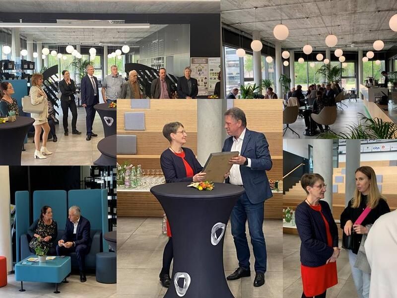 Eine Gruppe von Leuten steht in einem Raum um einen Tisch herum.