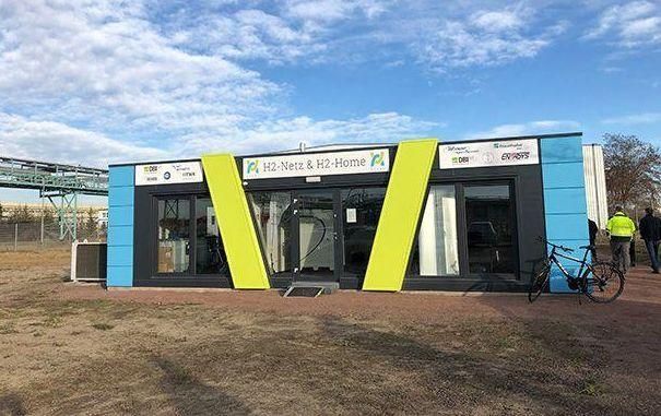 Ein blau-gelbes Gebäude, vor dem ein Fahrrad geparkt ist.