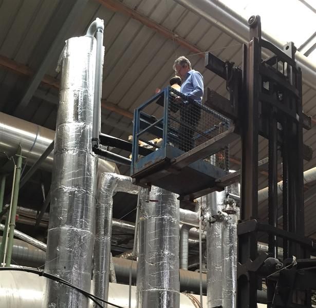 Ein Mann steht auf einem Gabelstapler in einer Fabrik