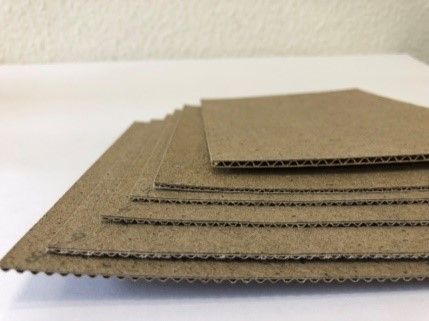 Ein Stapel übereinander gestapelter Pappbögen auf einem Tisch.