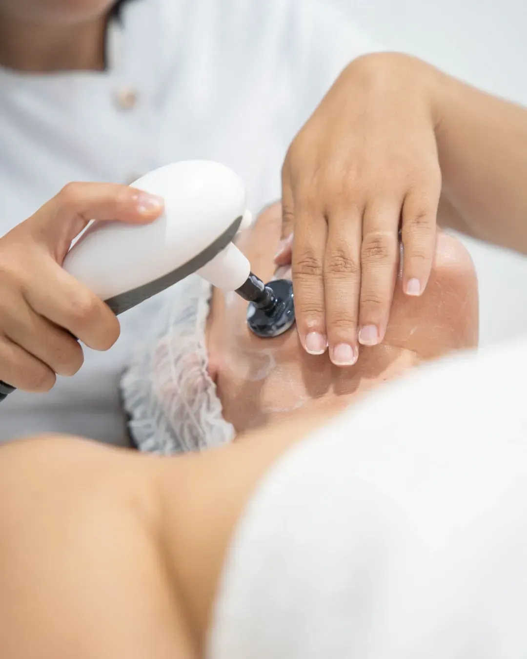 Tratamiento estético con un dispositivo manual aplicado en la mano de un cliente en un spa
