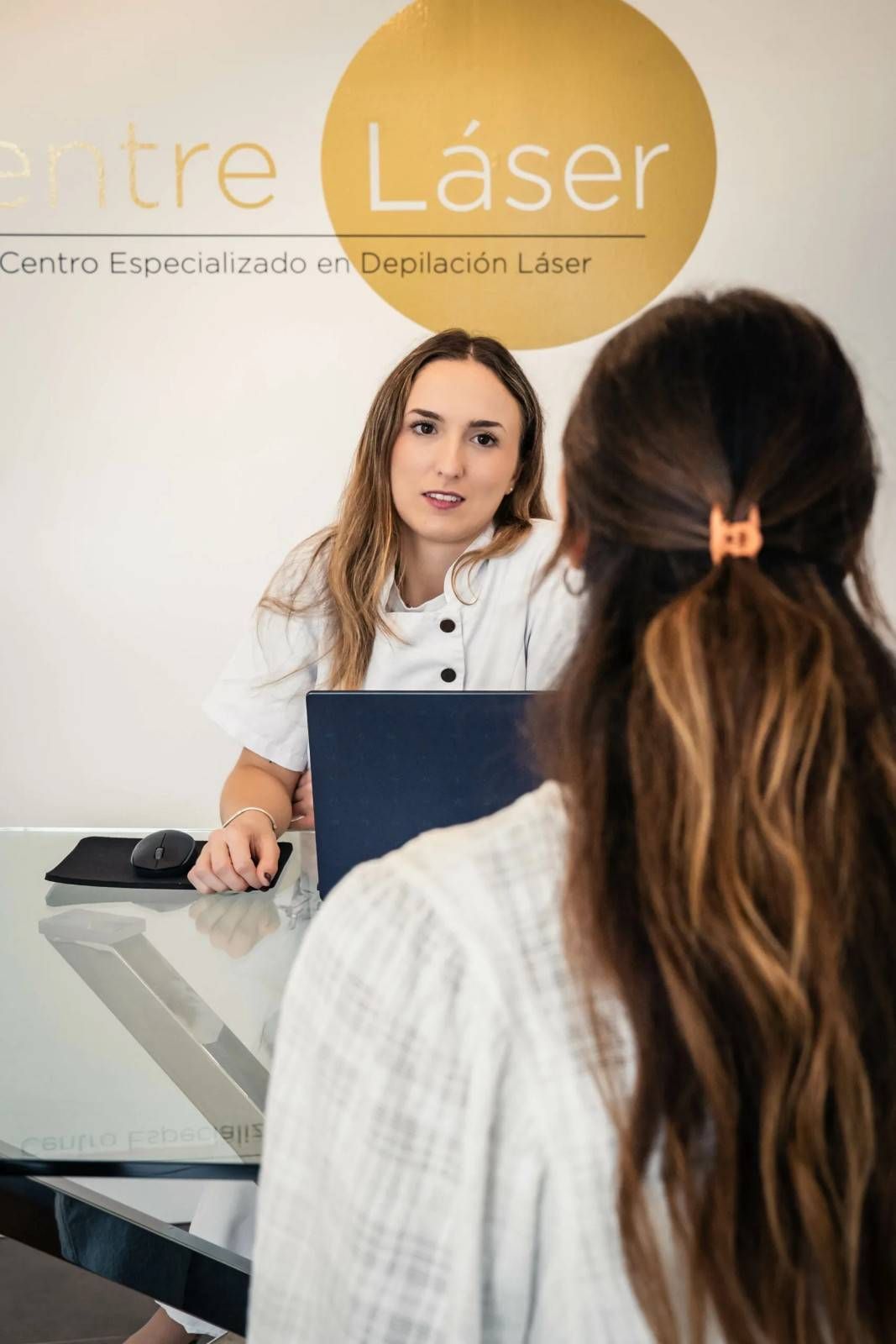 Una mujer habla con un cliente en el mostrador de