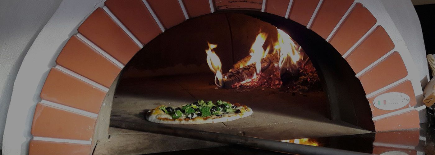 Eine Pizza wird in einem Steinofen gebacken