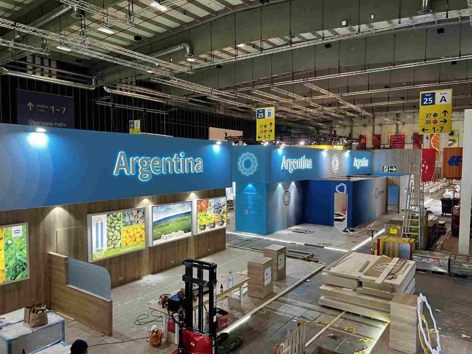 Stand de Argentina en una feria comercial, con carteles azules, vitrinas y un espacio de exposición abierto