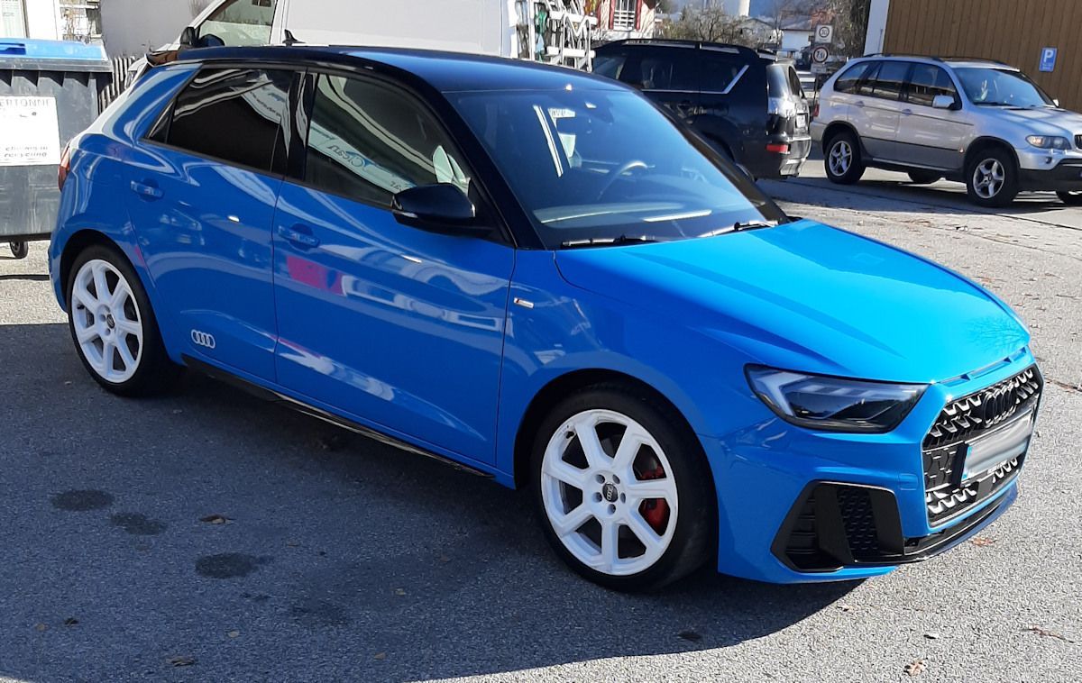 Auf einem Parkplatz steht ein blauer Audi A1.