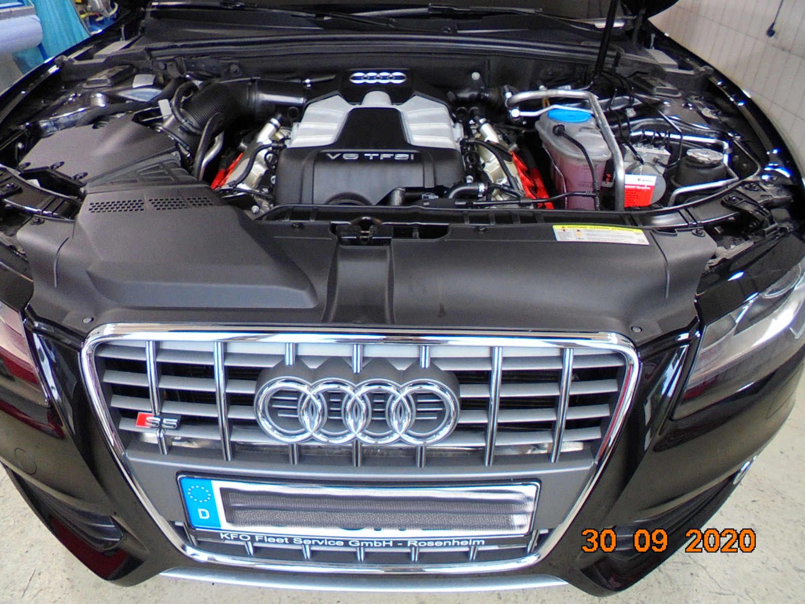 Ein schwarzer Audi mit geöffneter Motorhaube und sichtbarem, gereinigtem Motor