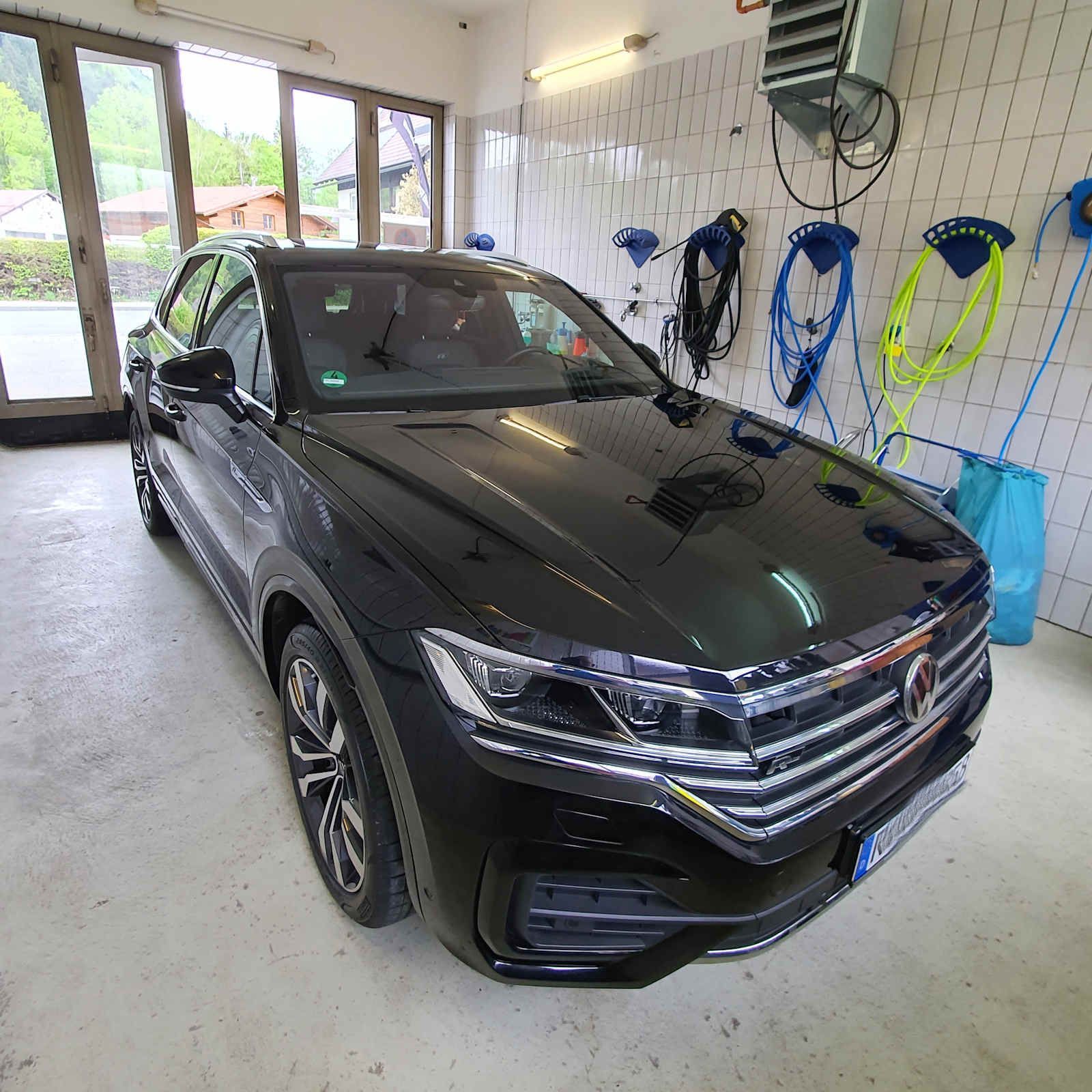 Ein schwarzes Auto steht in einer Garage