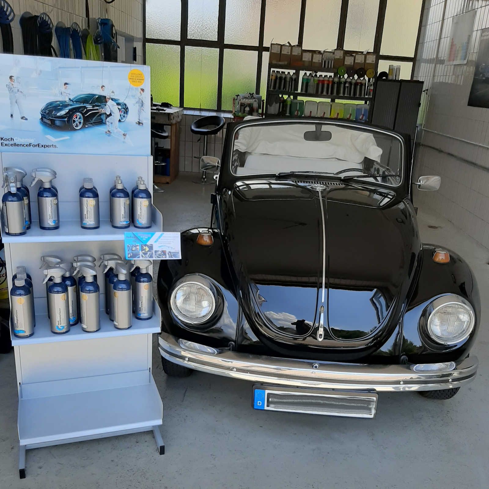 Ein schwarzes Auto steht neben einer Ausstellung von Sprühflaschen