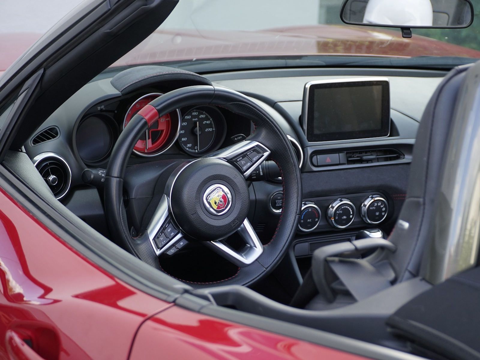 Der Innenraum eines roten Cabrio-Sportwagens mit Lenkrad