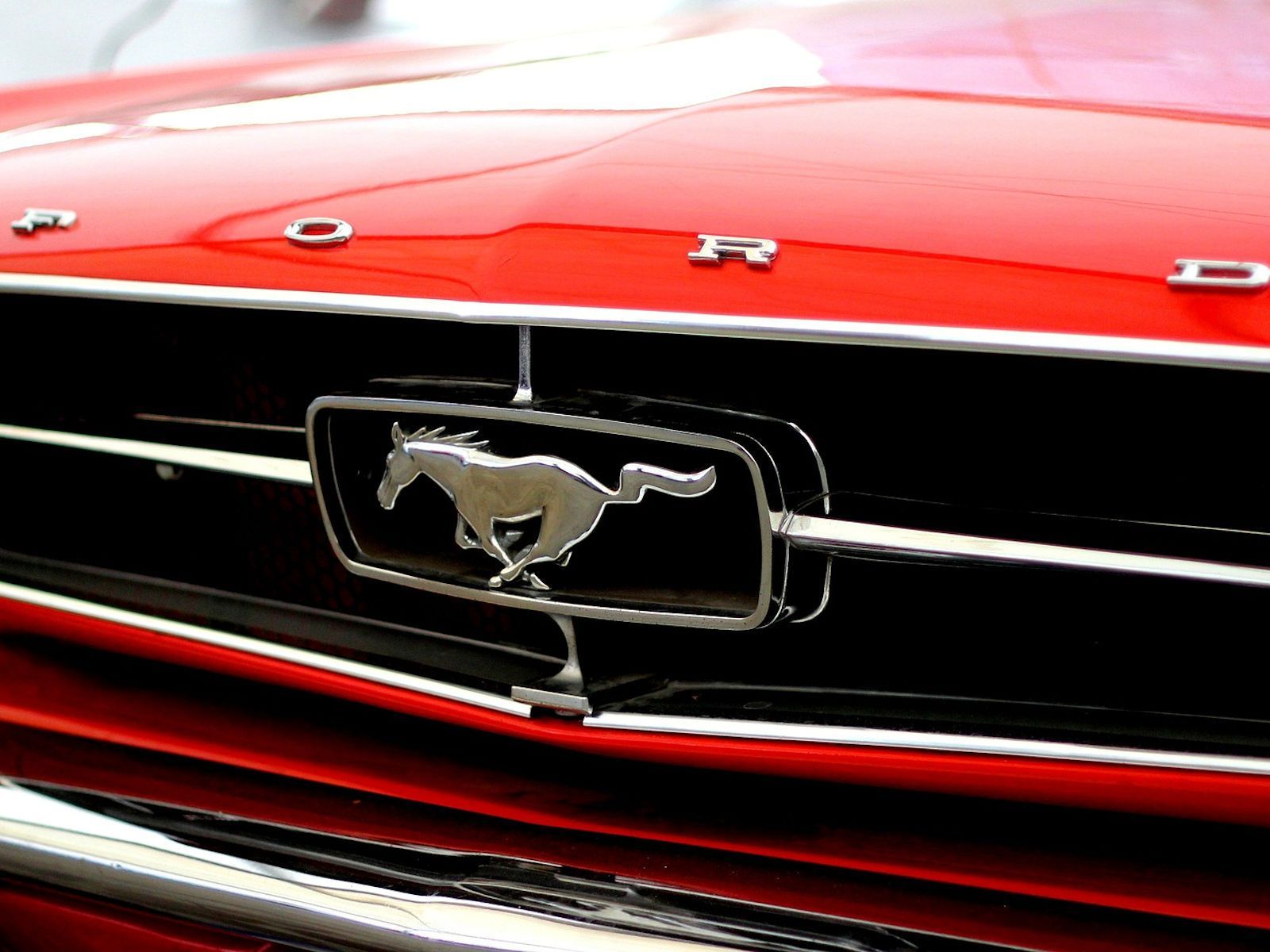 Ein roter Ford Mustang mit einem Pferd auf dem Kühlergrill