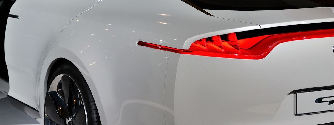 Eine Nahaufnahme eines weißen Autos mit einem roten Rücklicht.