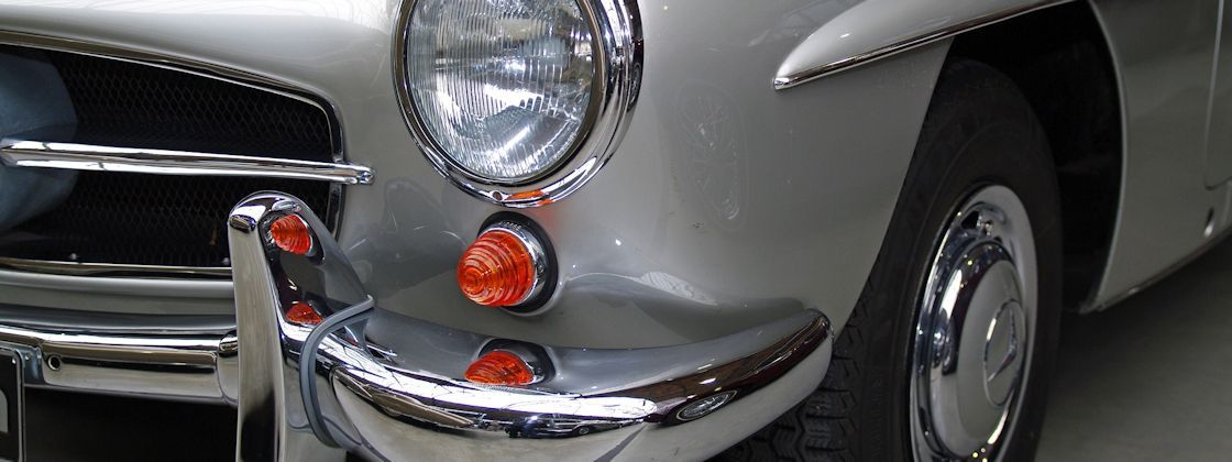 Eine Nahaufnahme der Vorderseite eines silbernen Autos mit roten Lichtern.
