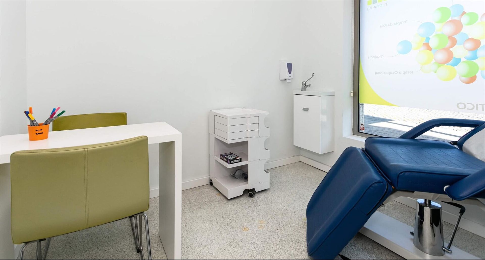 Consultório odontológico com cadeira, mesa e equipamentos médicos.