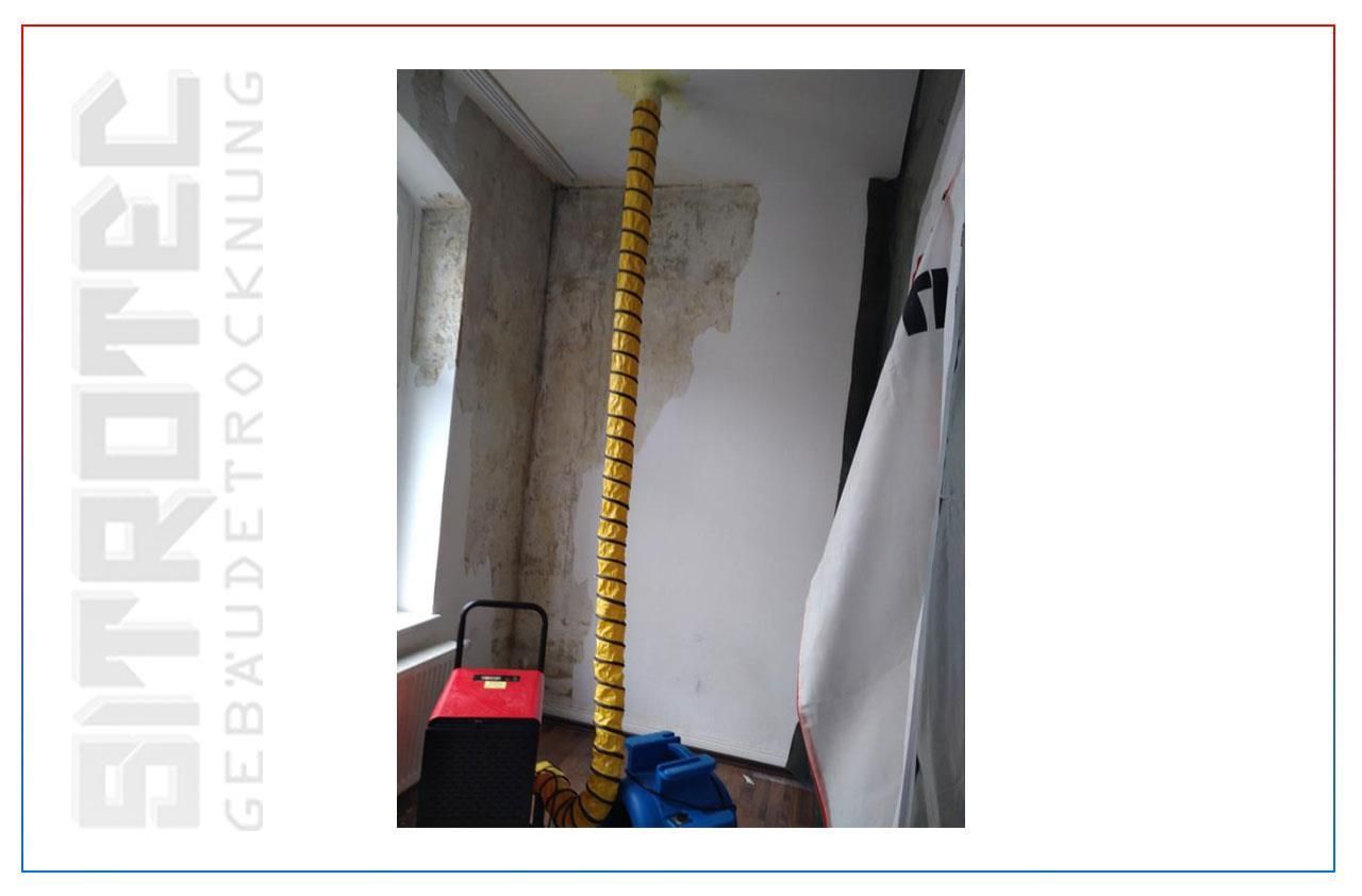 Ein Bild eines Raumes, von dessen Decke ein gelber Schlauch hängt.