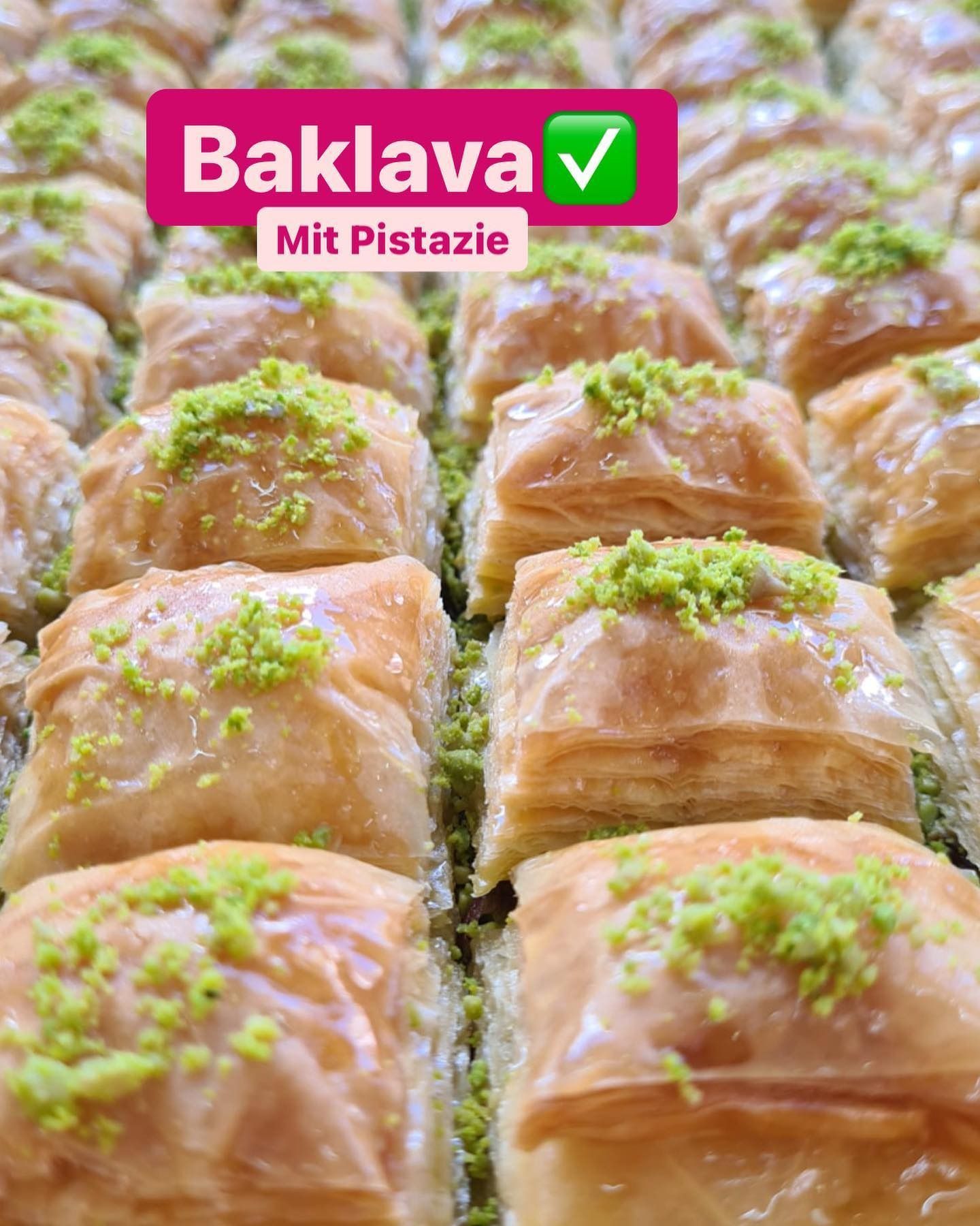 Tablett mit Pistazien-Baklava-Gebäck, garniert mit gehackten Nüssen und dem Etikett „Baklava mit Pistazie“.