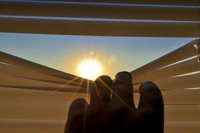 Die Sonne scheint durch die Jalousien eines Fensters