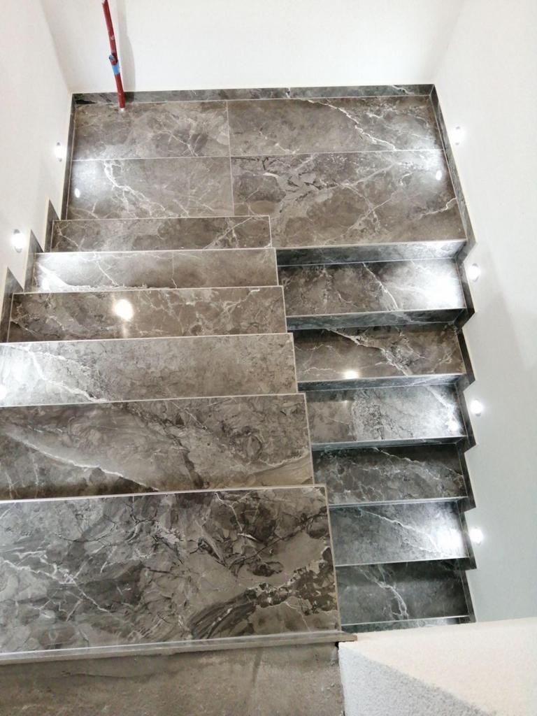 Un escalier en marbre menant au deuxième étage d'une maison.