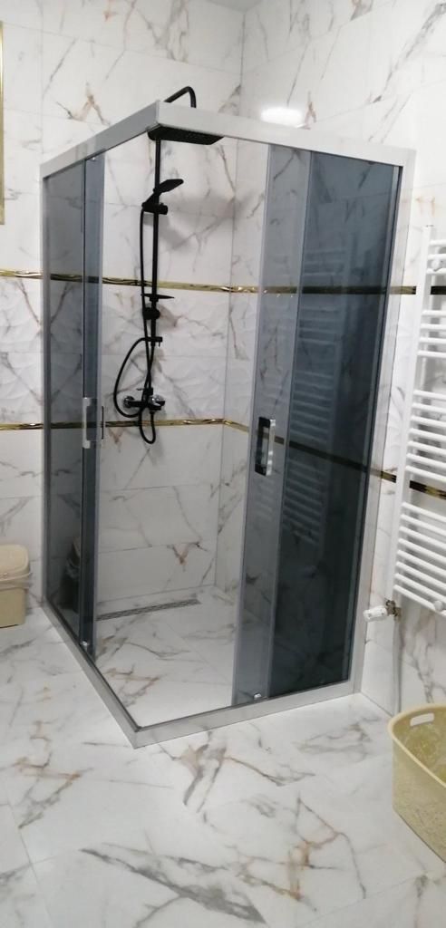 Une salle de bain avec cabine de douche avec du carrelage grand format