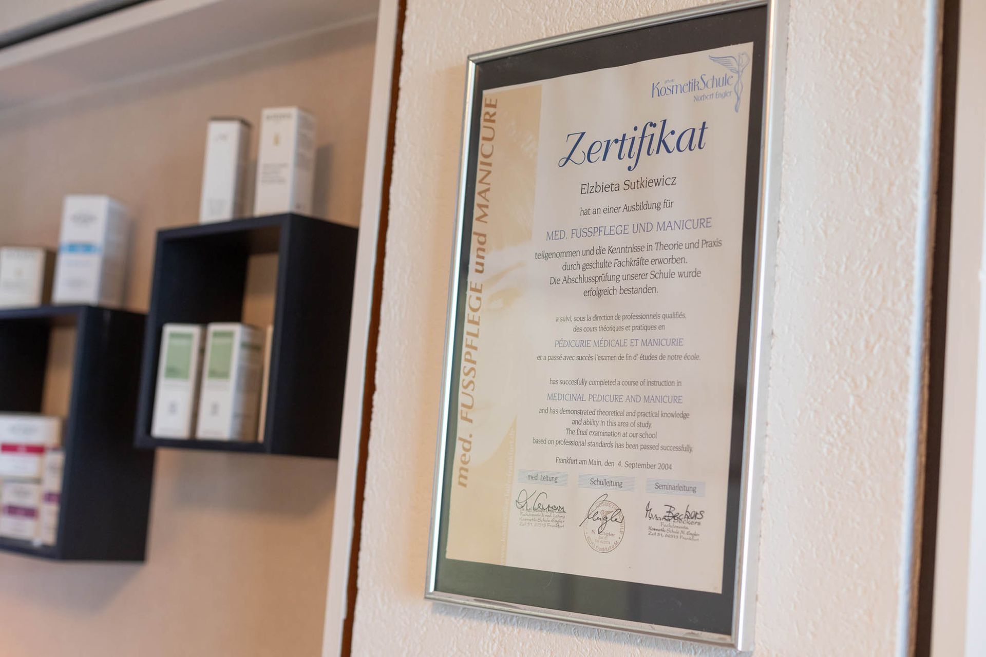 Ein Zertifikat hängt gerahmt an der Wand in einem Raum