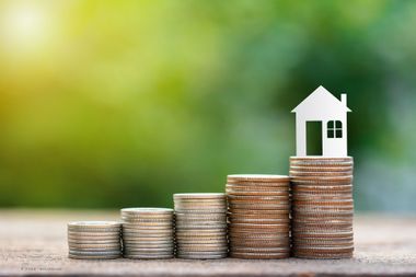 Fünf größer werdende Münzenstapel höchster mit Hausicon