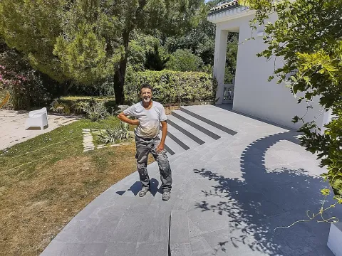M. Roux pose sur une terrasse en carrelage