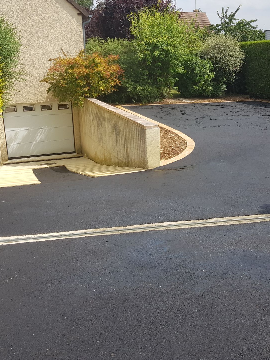 Allée goudronnée qui descend vers le garage