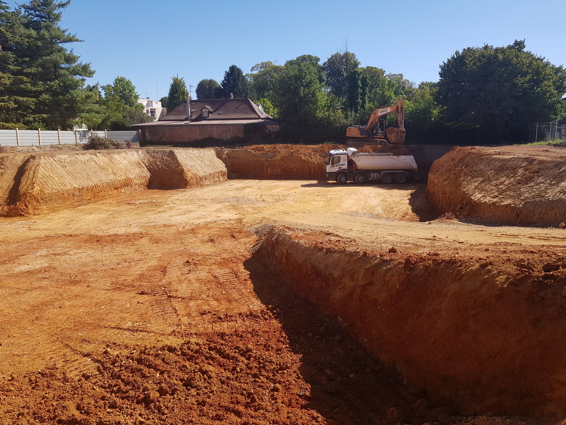 Grand terrain creusé pour les fondations - camion-benne dans le terrain