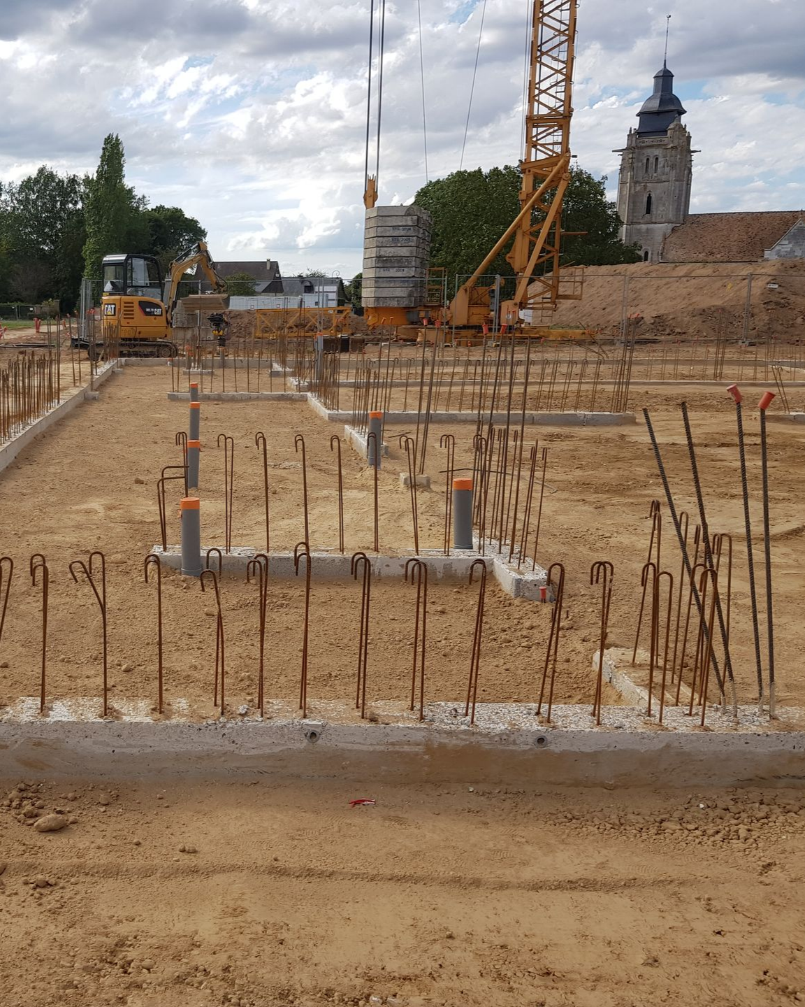 Fondations préparées pour une future construction - église en fond